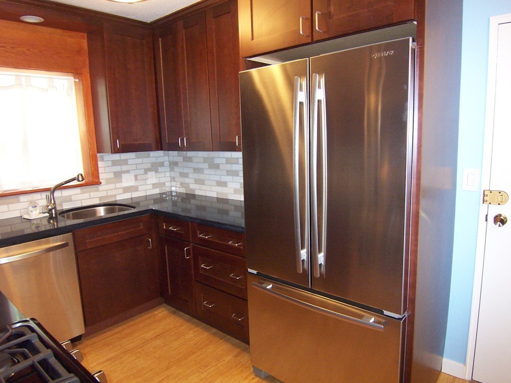 140 Lake Shore Road, Unit 1 Boston, MA 02135 - Photo 6 of 26 a kitchen with granite countertop a refrigerator and a sink