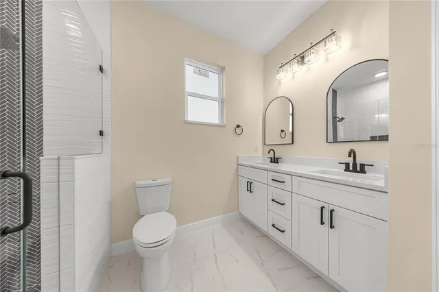 a spacious bathroom with a toilet a sink and a mirror