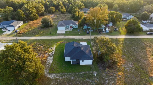 an aerial view of a house with a yard basket ball court and outdoor seating