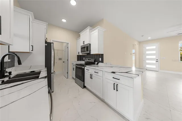 a kitchen with stainless steel appliances a sink stove and refrigerator