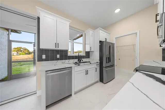 a kitchen with stainless steel appliances granite countertop a refrigerator and a stove