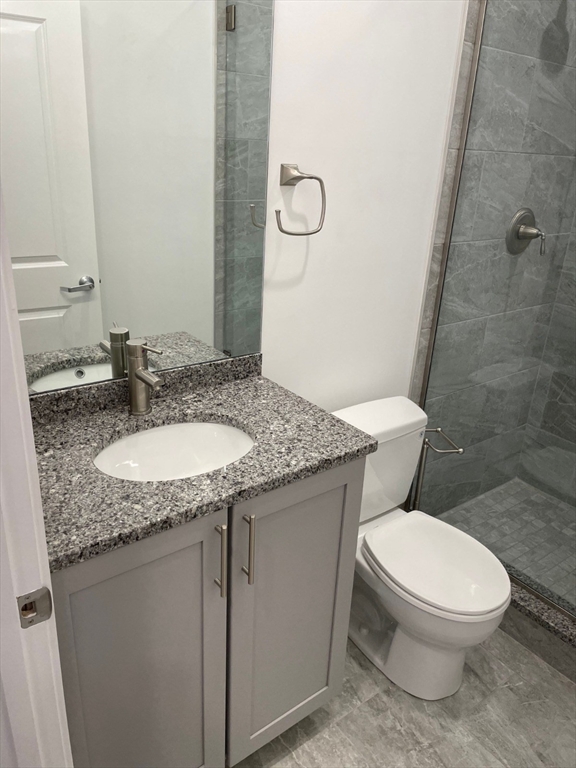 64 Market Street, Unit 401 Lynn, MA 01901 - Photo 8 of 14 a bathroom with a granite countertop toilet a sink and a mirror