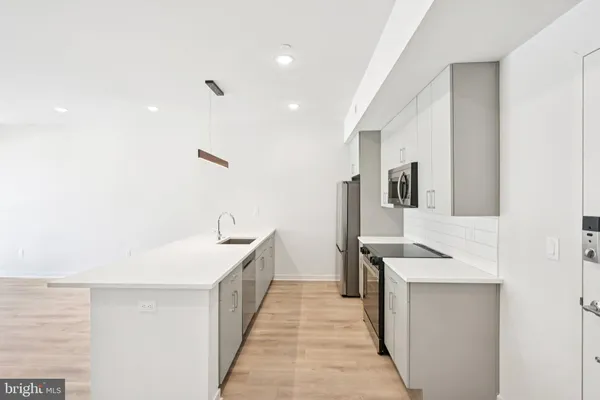 a kitchen with a sink and wooden floor