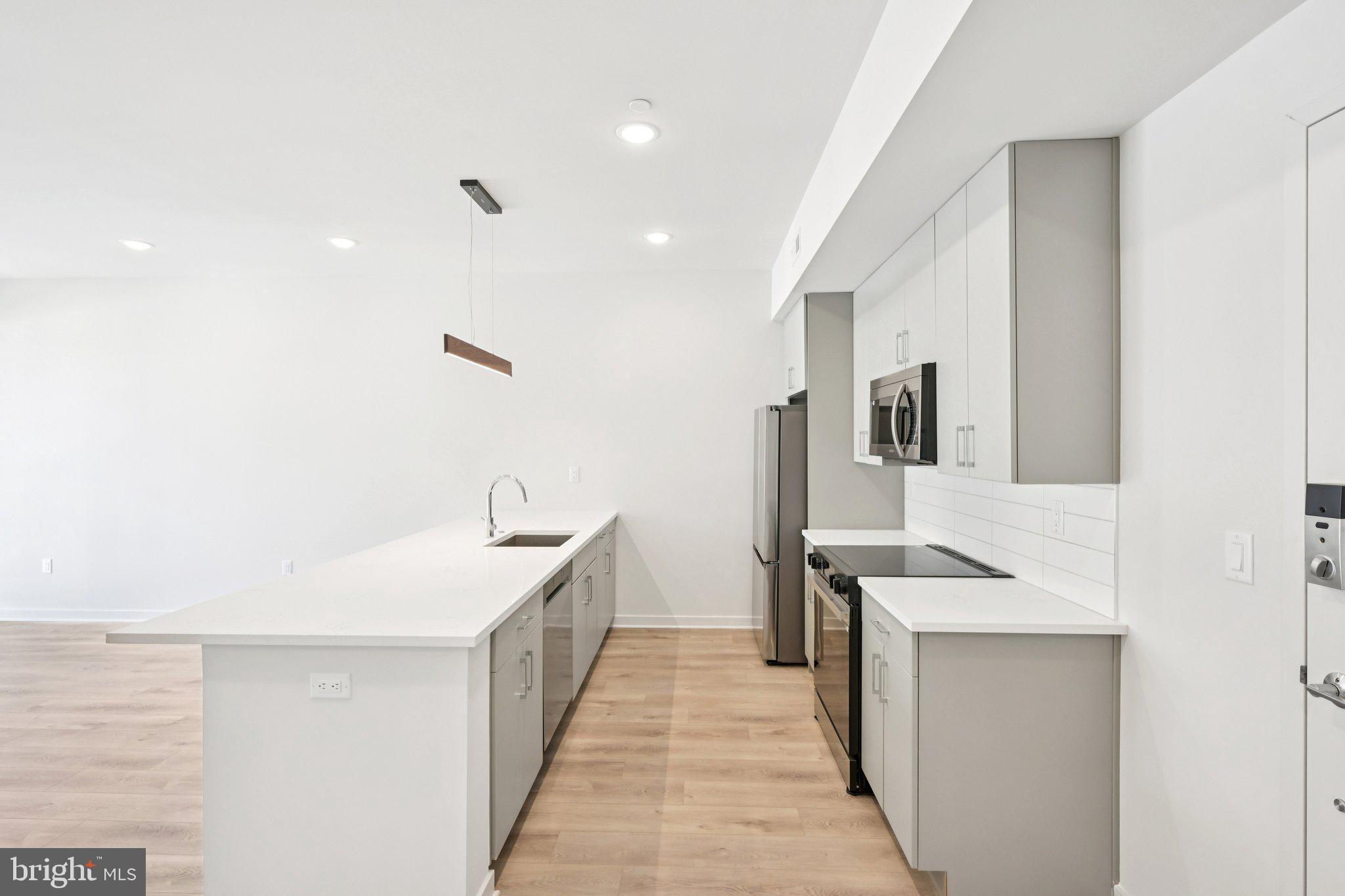 23 Rock Hill Road, Unit 203 Bala Cynwyd, PA 19004 - Photo 4 of 8 a kitchen with a sink and wooden floor