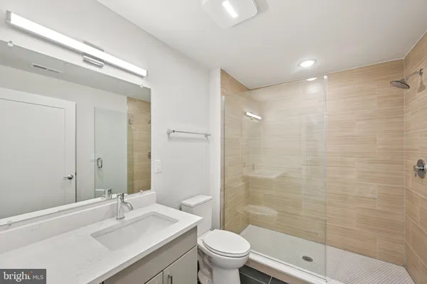 a bathroom with a sink a toilet and shower
