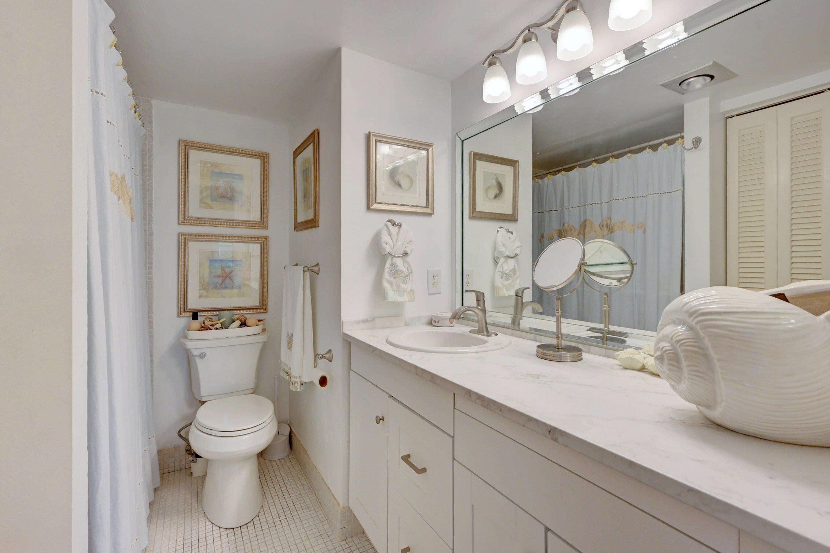 2049 Newcastle A, Unit 2049 Boca Raton, FL 33434 - Photo 17 of 24 a bathroom with a toilet a sink and mirror