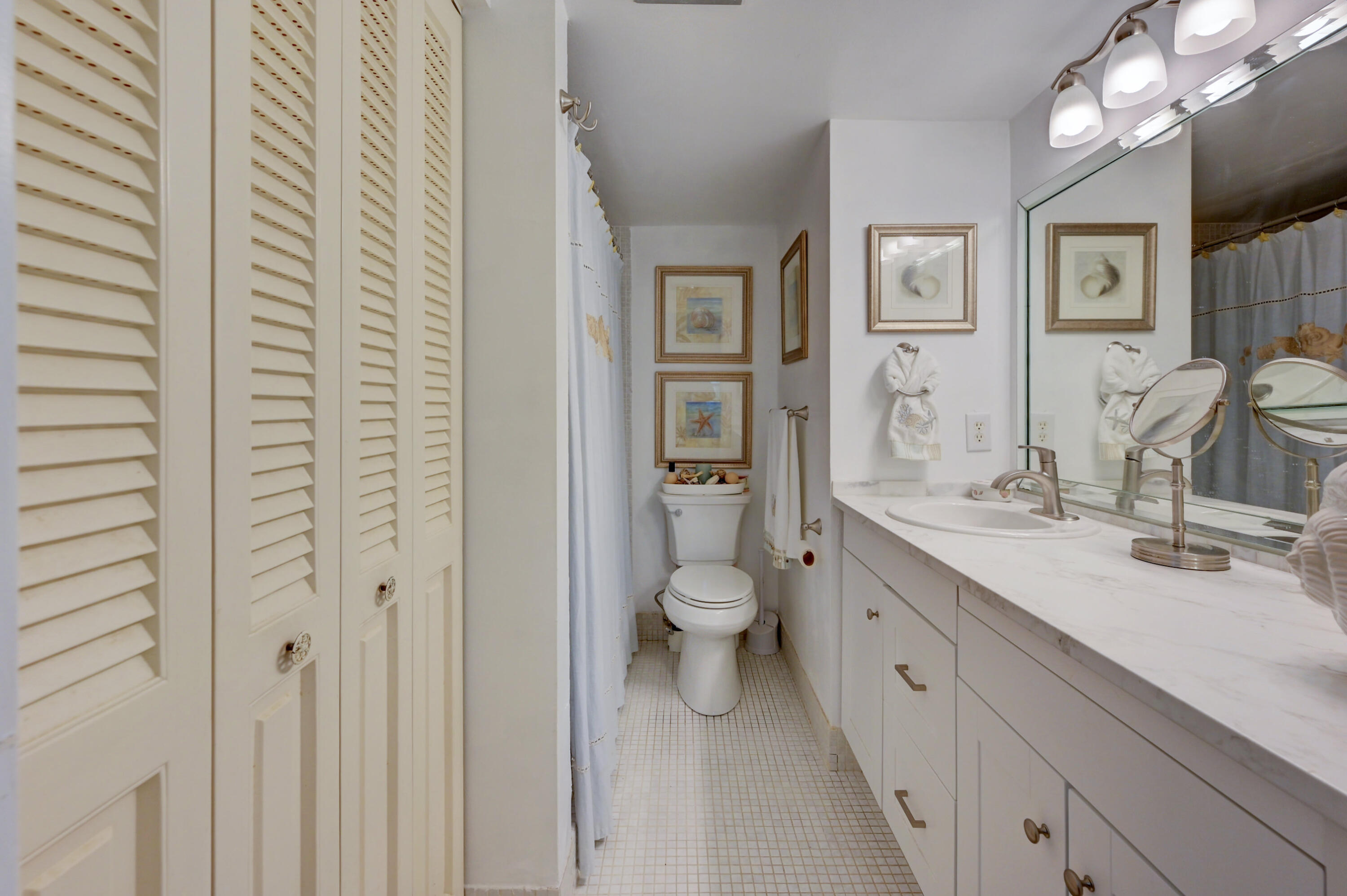 2049 Newcastle A, Unit 2049 Boca Raton, FL 33434 - Photo 18 of 24 a spacious bathroom with a double vanity sink a mirror and a toilet