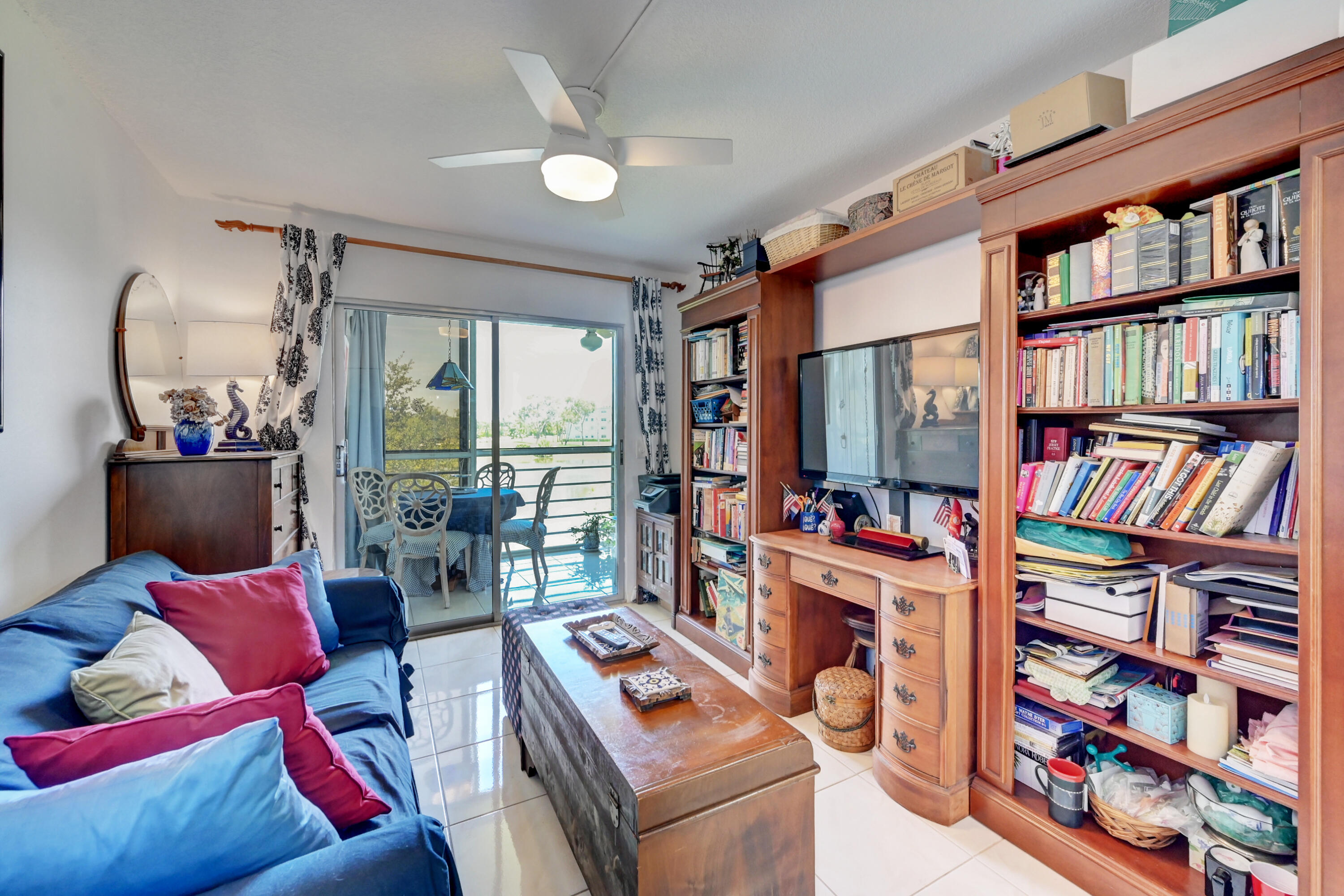 2049 Newcastle A, Unit 2049 Boca Raton, FL 33434 - Photo 20 of 24 a living room with lots of furniture and a book shelf