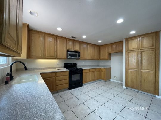1133 West Benson Avenue Ridgecrest, CA 93555 - Photo 8 of 34 a kitchen with stainless steel appliances granite countertop a refrigerator sink and cabinets