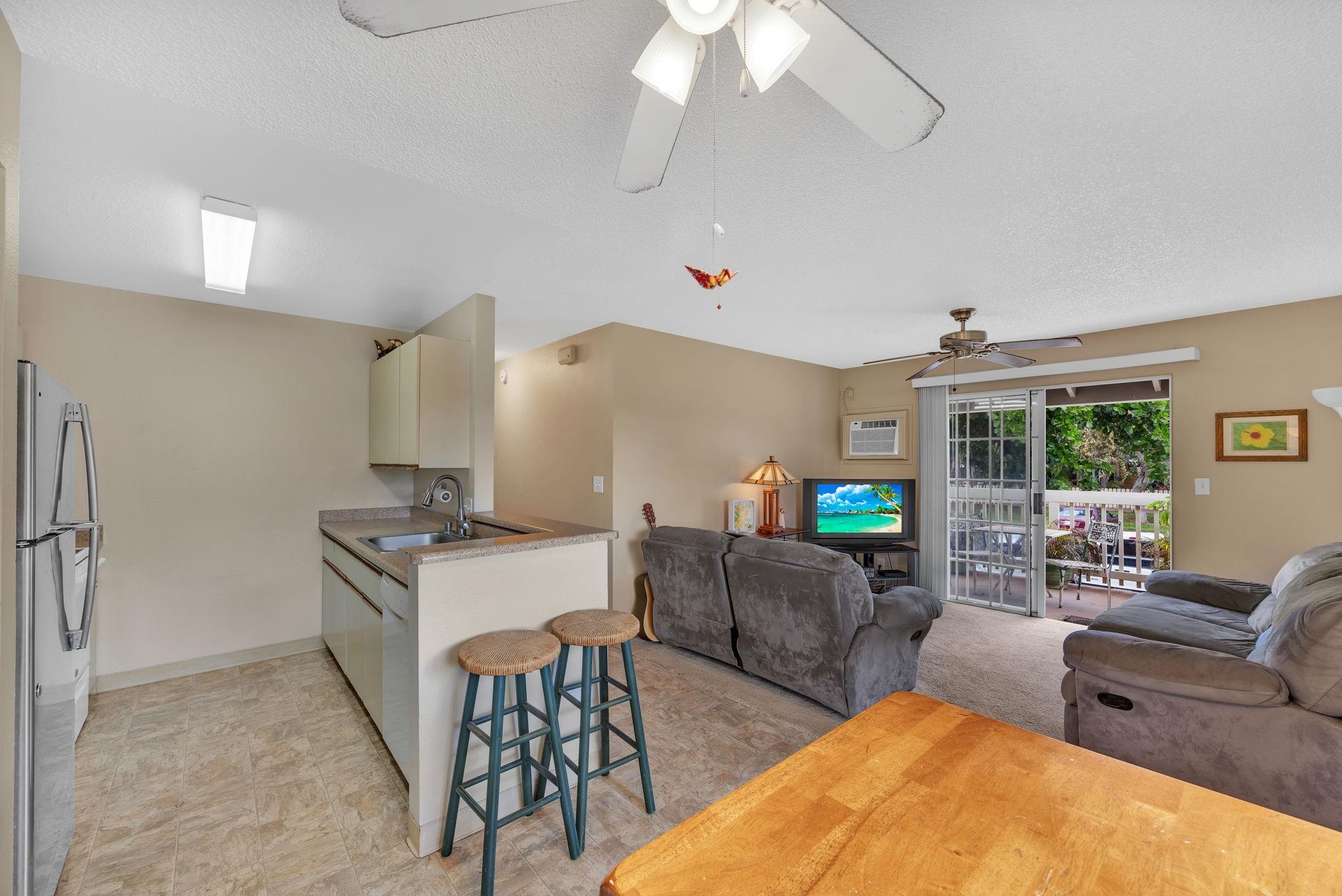 140 Uwapo Road, Unit 9202 Kihei, HI 96753 - Photo 13 of 31 a living room with furniture a chandelier and a flat screen tv