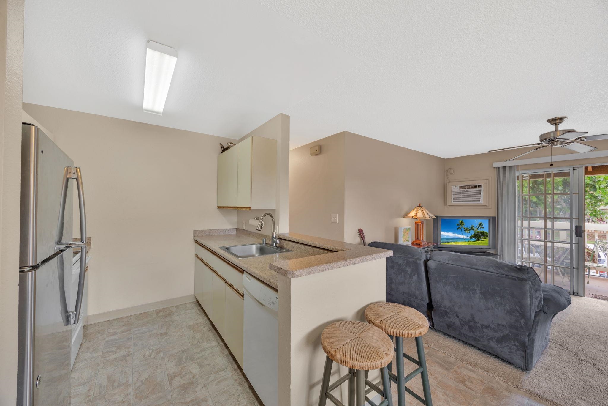 140 Uwapo Road, Unit 9202 Kihei, HI 96753 - Photo 14 of 31 a living room with stainless steel appliances furniture a rug and a kitchen view