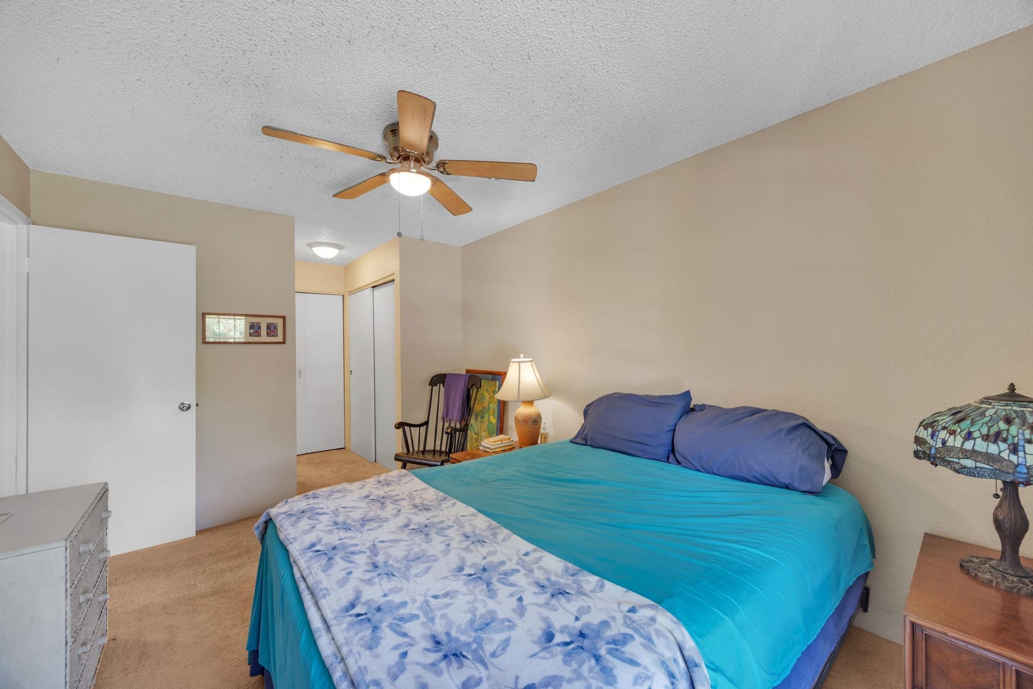 140 Uwapo Road, Unit 9202 Kihei, HI 96753 - Photo 21 of 31 a bedroom with a bed and a chandelier