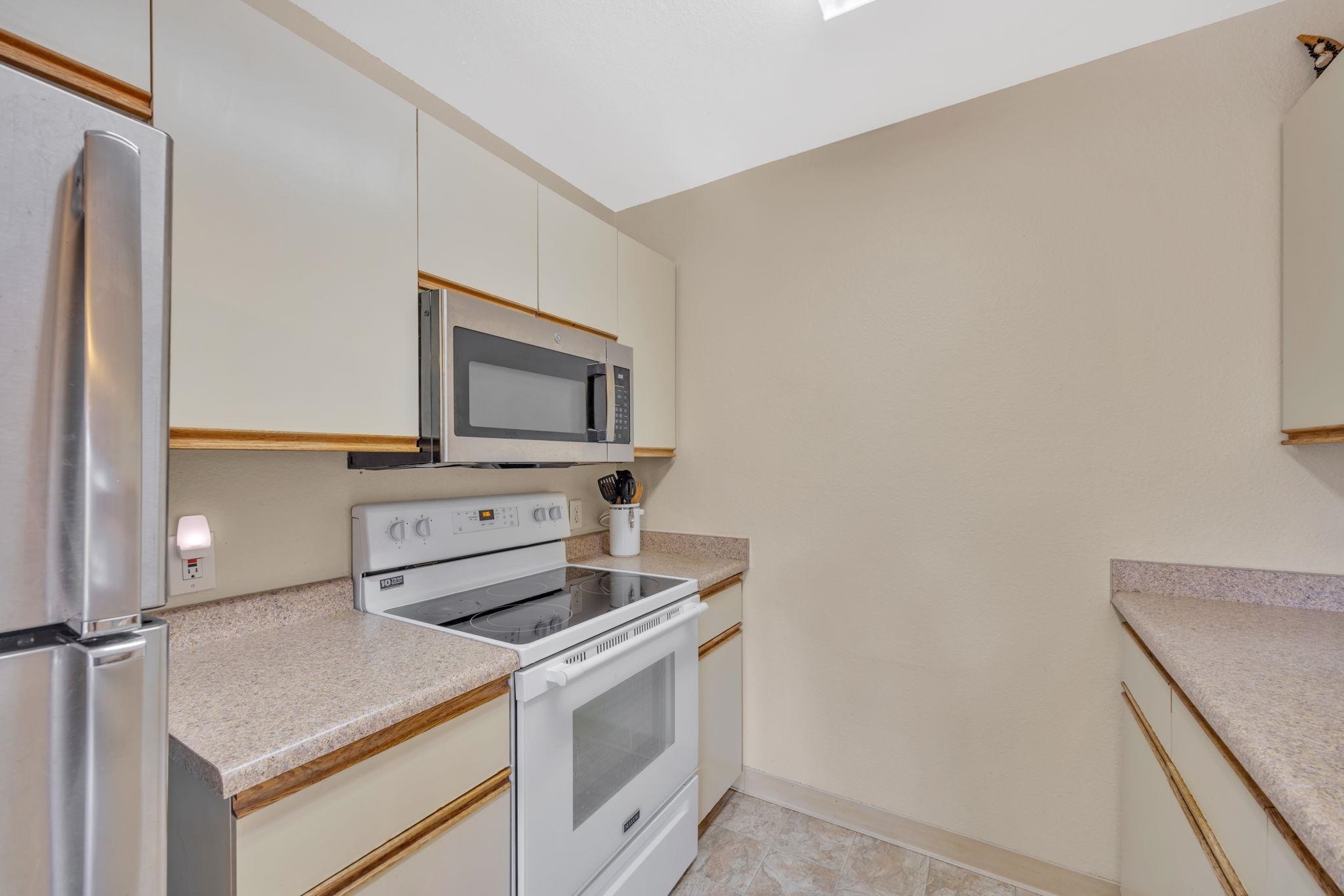 140 Uwapo Road, Unit 9202 Kihei, HI 96753 - Photo 6 of 31 a kitchen with a stove and a microwave