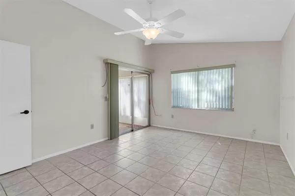 an empty room with fan and windows