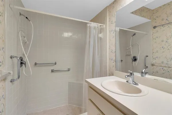 a bathroom with a sink a shower and a mirror