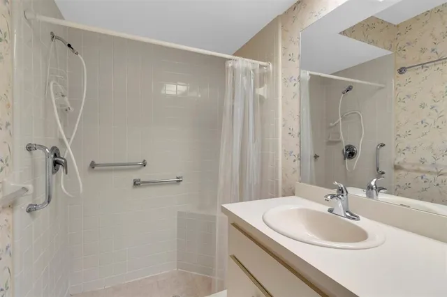 a bathroom with a sink a shower and a mirror