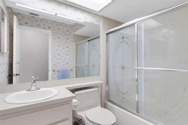 a bathroom with a toilet sink shower and mirror