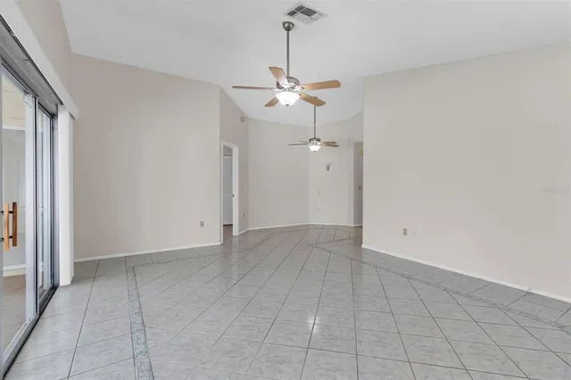 an empty room with a ceiling fan and window