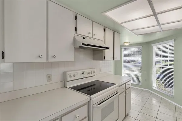 a kitchen with granite countertop white cabinets and white appliances