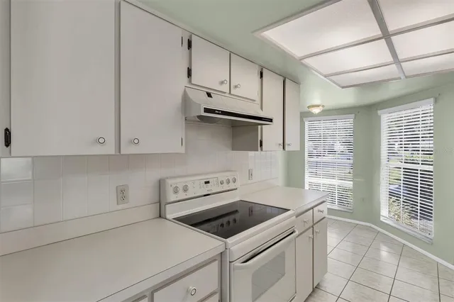 a kitchen with granite countertop white cabinets and white appliances