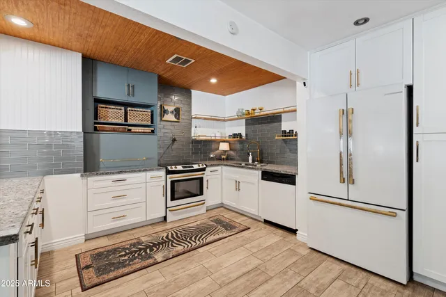 a kitchen with granite countertop stainless steel appliances and white cabinets