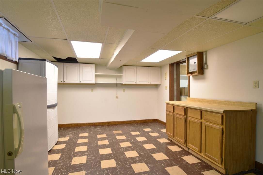 28740 Forest Road Willowick, OH 44095 - Photo 21 of 27 Basement with stainless steel fridge and a paneled ceiling