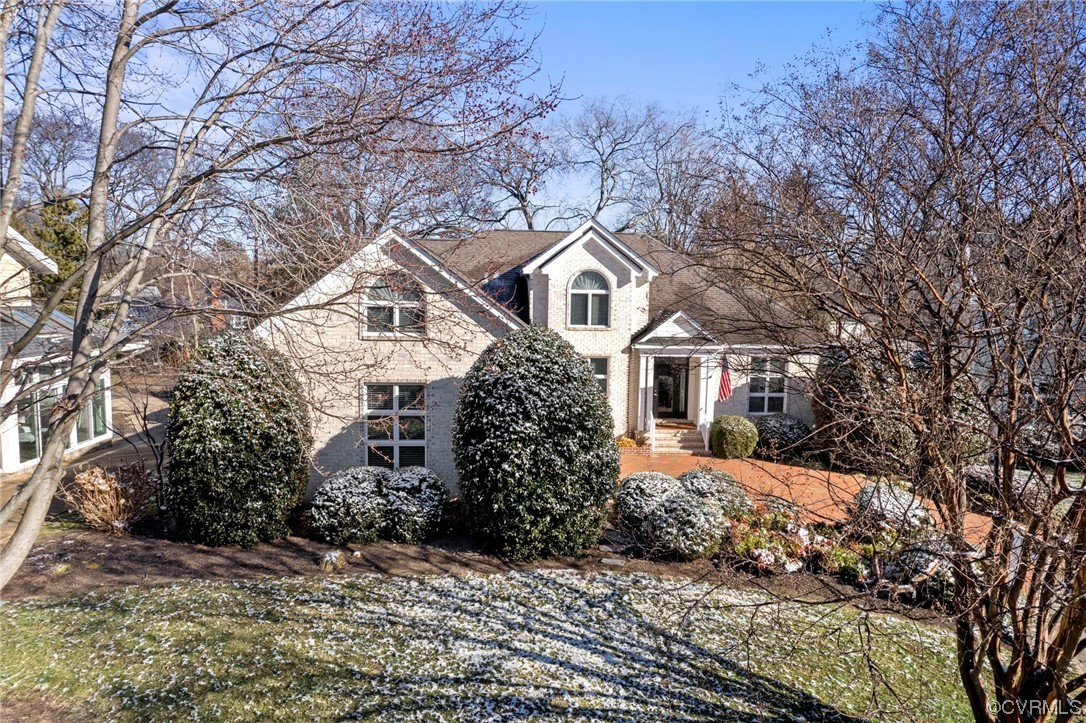 a front view of a house with a yard covered in snow