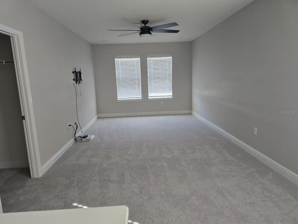 10916 Honor Road Tampa, FL 33625 - Photo 18 of 36 an empty room with windows and a ceiling fan