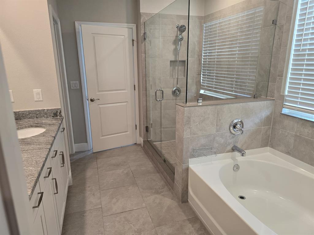 10916 Honor Road Tampa, FL 33625 - Photo 25 of 36 a bathroom with a bathtub and a shower
