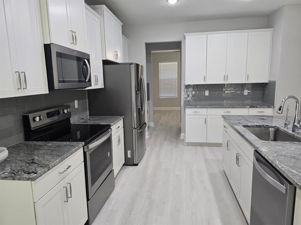 10916 Honor Road Tampa, FL 33625 - Photo 10 of 36 a kitchen with stainless steel appliances granite countertop a sink stove and refrigerator