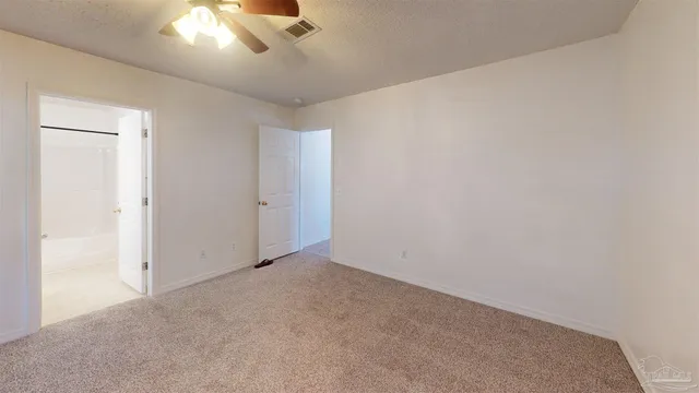 an empty room with a chandelier fan