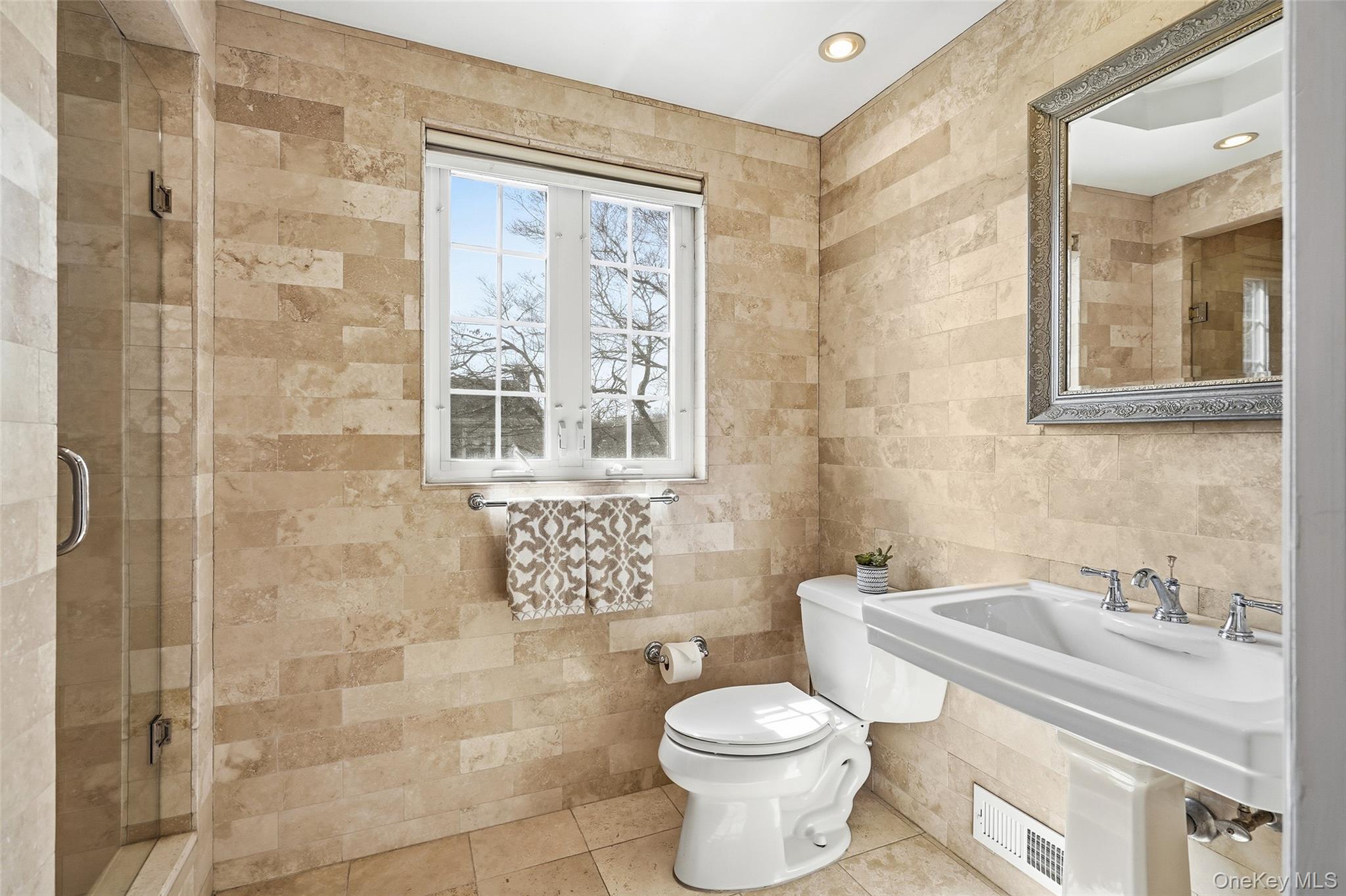 42 Sargent Road Scarsdale, NY 10583 - Photo 16 of 27 Ensuite primary bathroom featuring a shower stall, tile walls, and tile patterned floors.