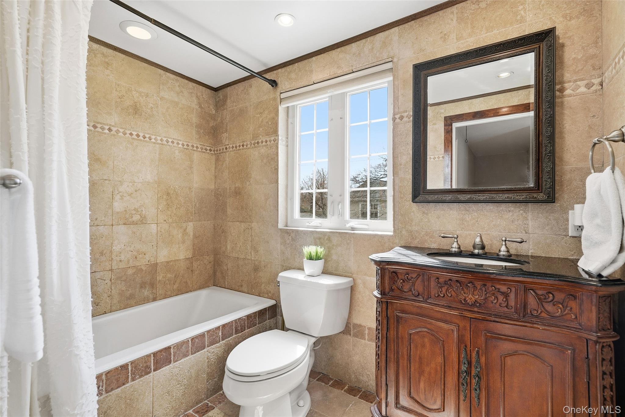 42 Sargent Road Scarsdale, NY 10583 - Photo 19 of 27 Bathroom with tile walls, vanity, tiled shower / bath, crown molding, and recessed lighting.