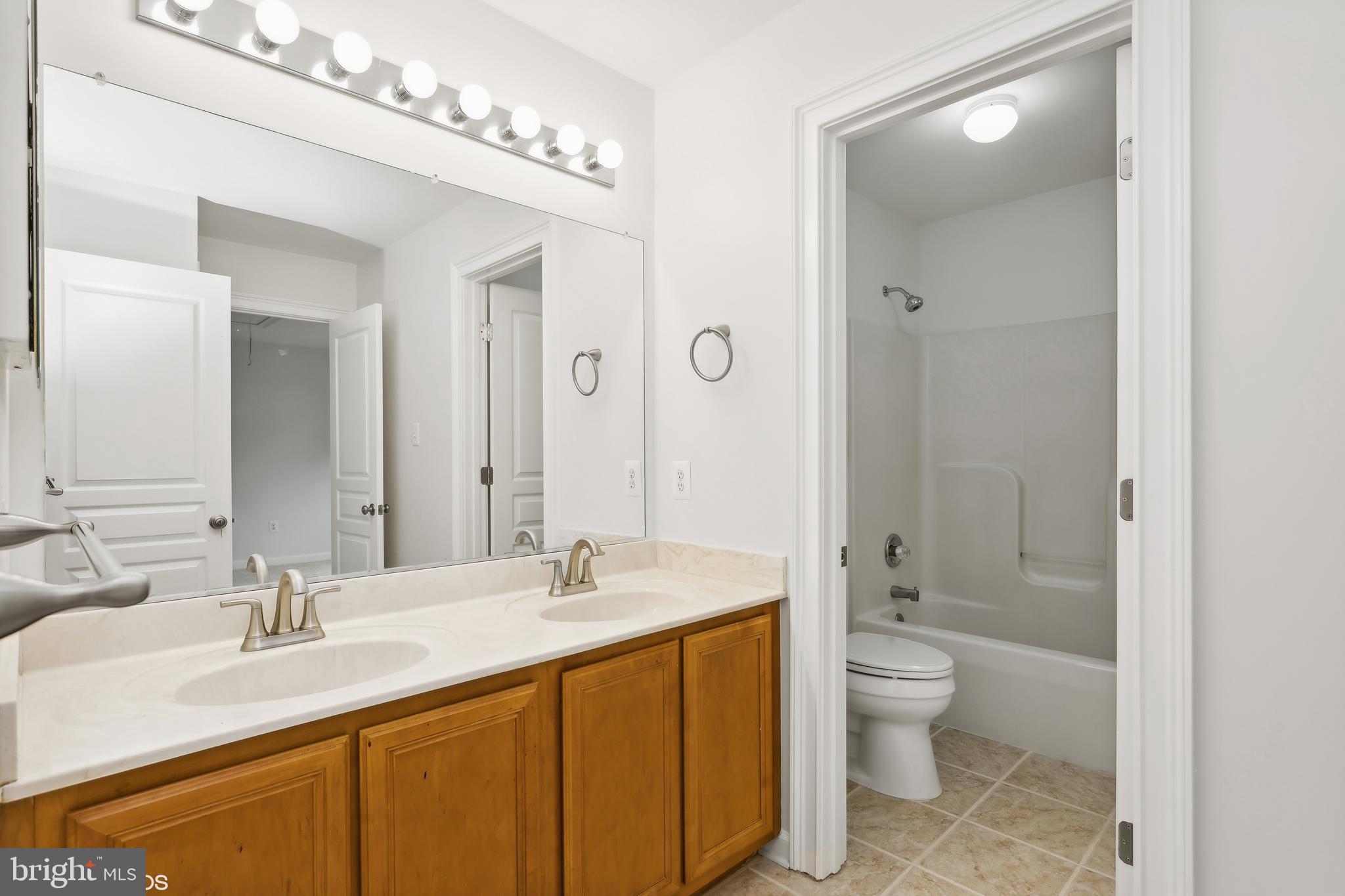 818 Hoods Mill Road Cooksville, MD 21723 - Photo 57 of 108 a bathroom with a double vanity sink toilet mirror and bathtub