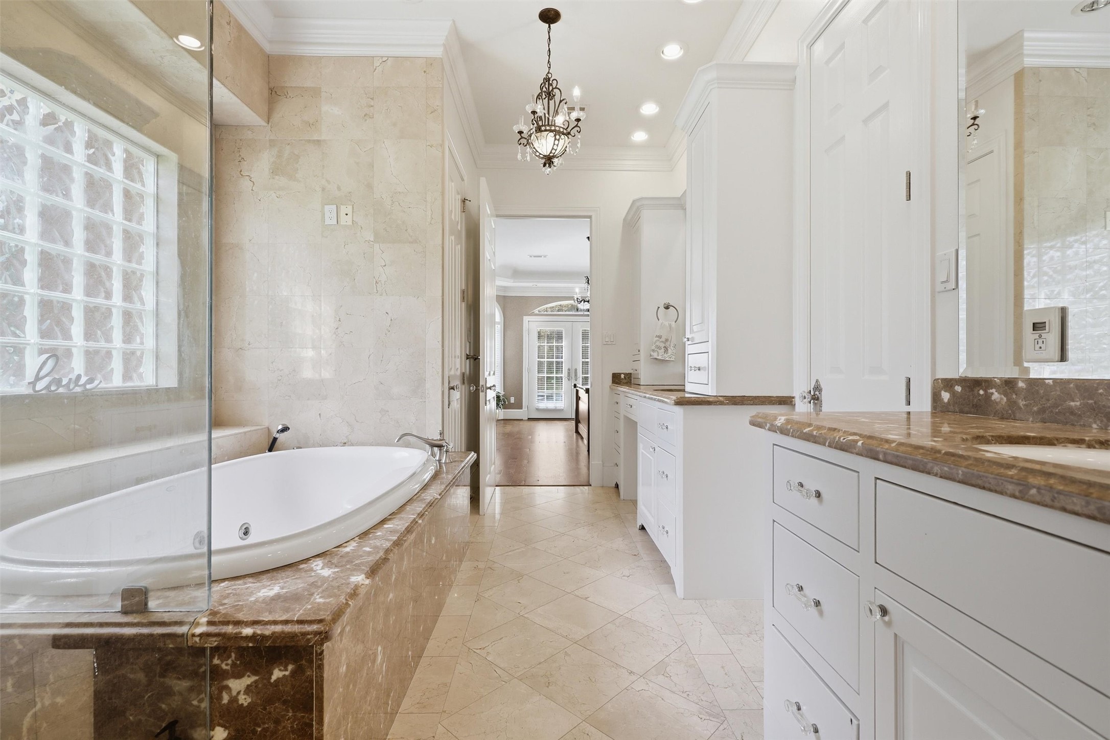 8582 Highway 75 Huntsville, TX 77340 - Photo 27 of 50 a large bathroom with a double vanity sink a large mirror and a bathtub