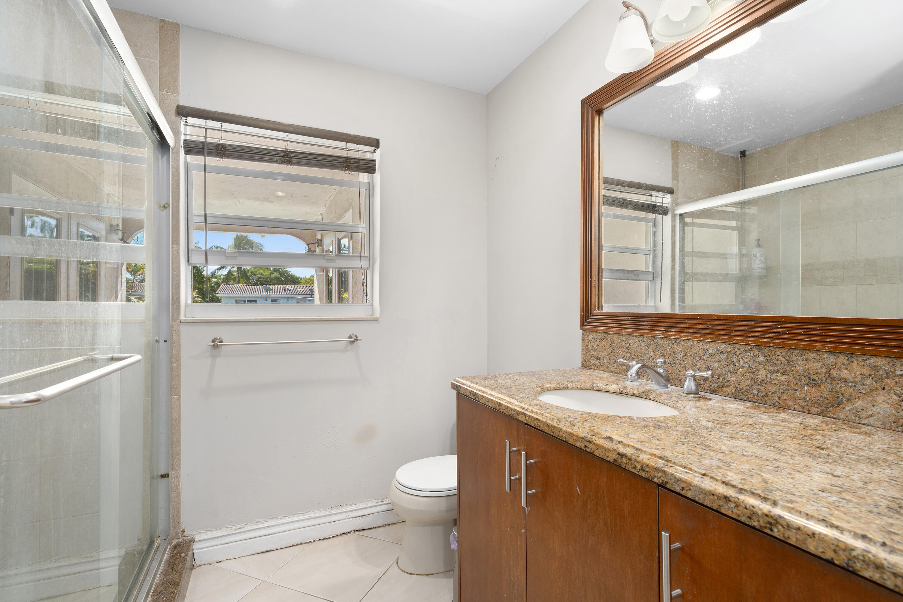 250 Northwest 11th Street Boca Raton, FL 33432 - Photo 13 of 30 a bathroom with a granite countertop sink toilet and shower