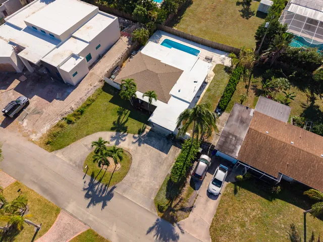 an aerial view of a house with swimming pool and lake view