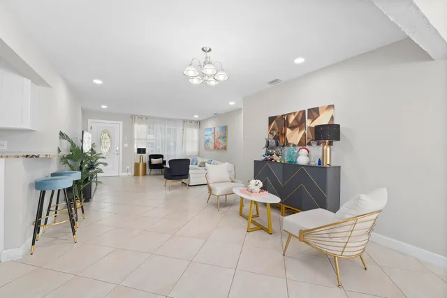 a living room with furniture a dining table and a potted plant