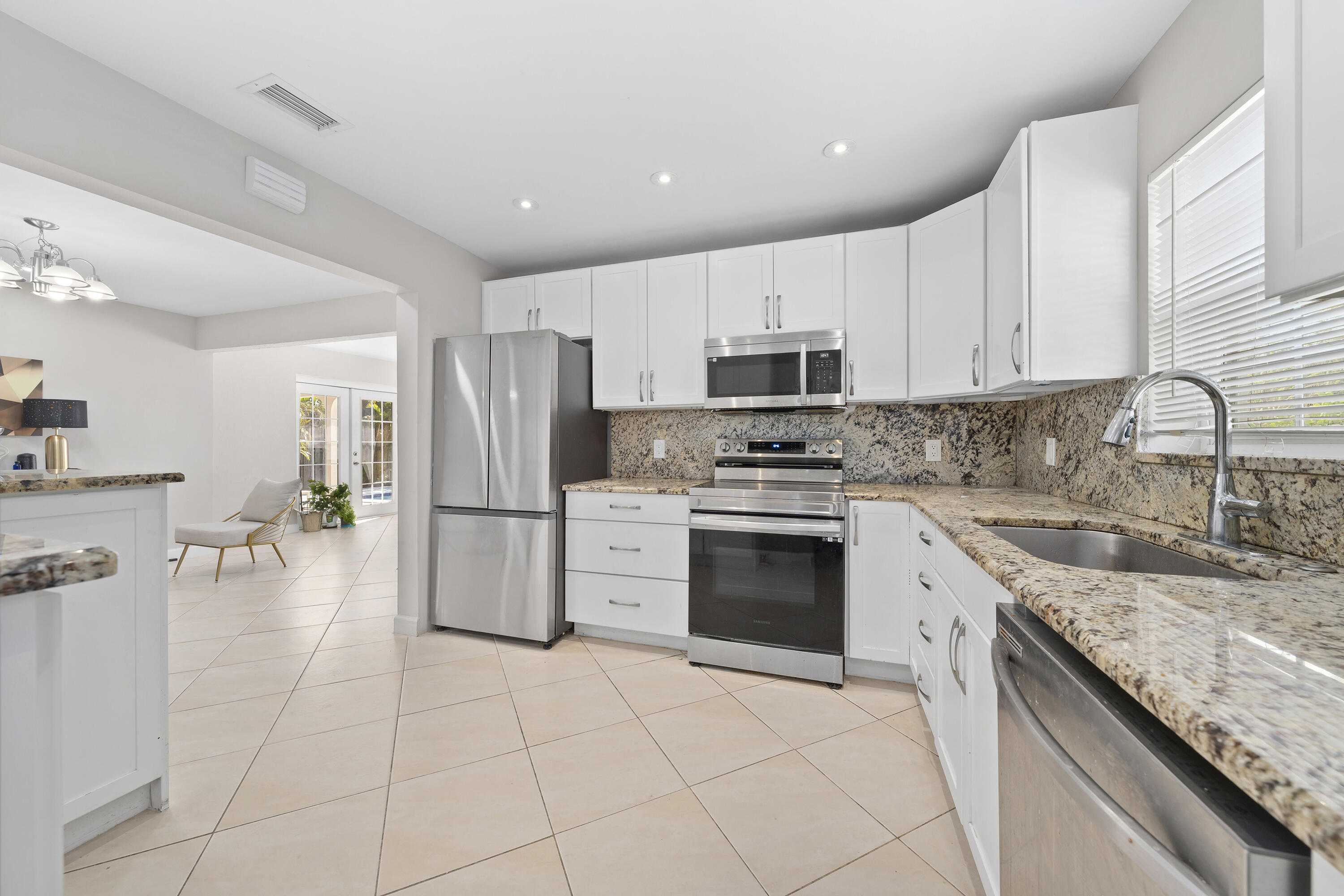 250 Northwest 11th Street Boca Raton, FL 33432 - Photo 8 of 30 a kitchen with a sink a refrigerator and cabinets