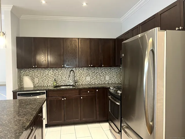a kitchen with granite countertop stainless steel appliances and wooden cabinets