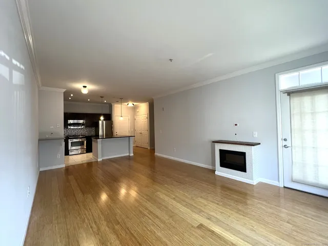 a view of empty room with wooden floor and fireplace
