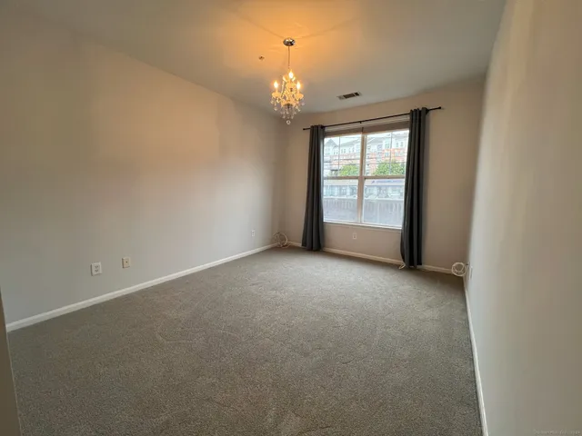 a view of a big room with windows and chandelier fan