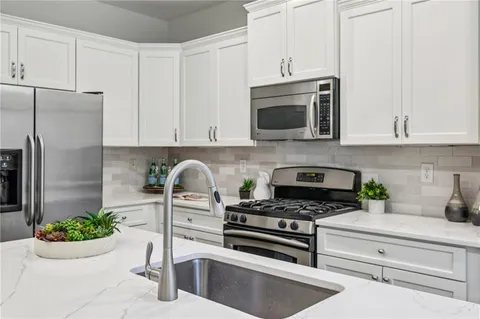 a view of a patio with a table and chairs and floor to ceiling window and wooden fence