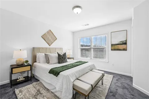 a bedroom with a bed and painting on the wall