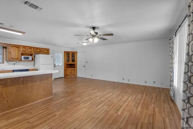 wooden floor in an empty room with a kitchen
