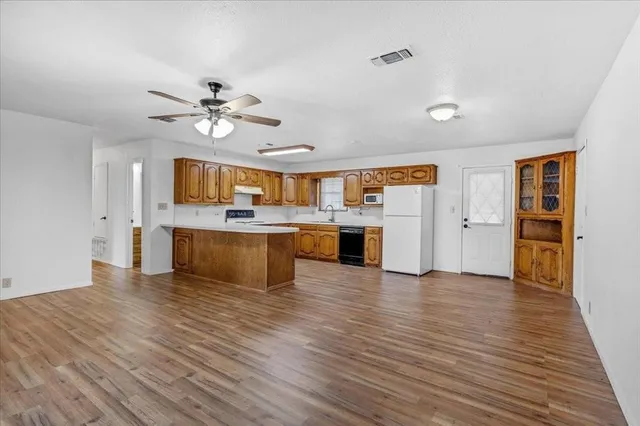 a view of a kitchen with a sink dishwasher a kitchen view with wooden floor and a kitchen view