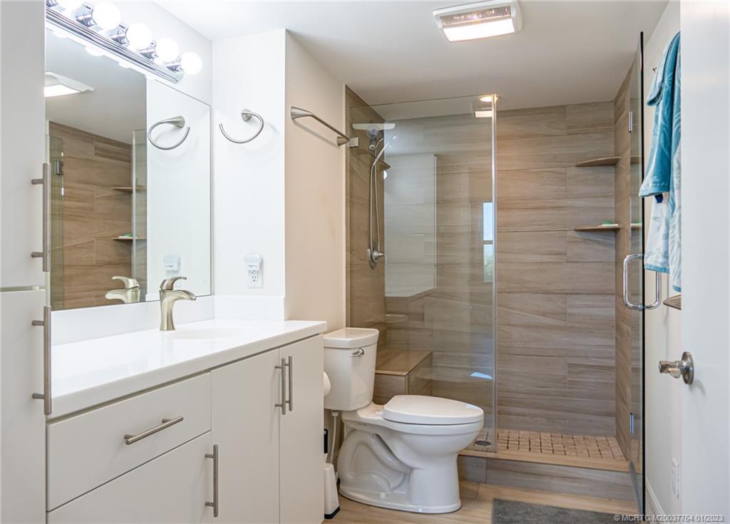 245 Northeast MacArthur Boulevard, Unit 5 Stuart, FL 34996 - Photo 16 of 38 a bathroom with a sink a toilet and shower