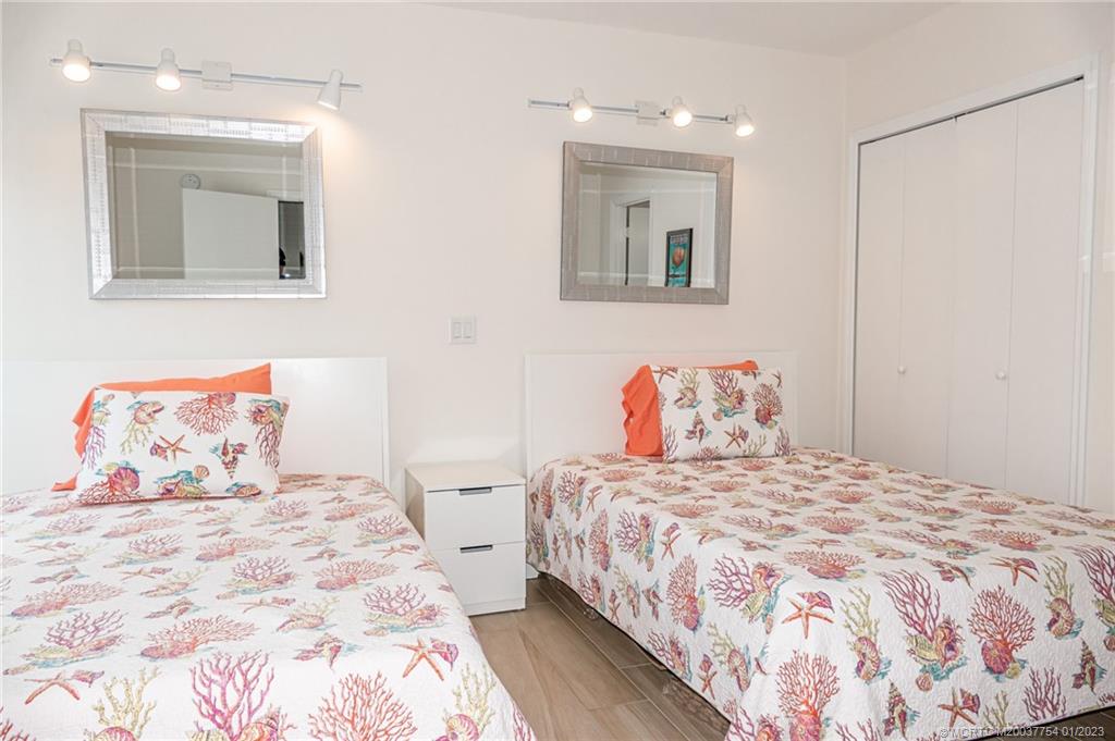 245 Northeast MacArthur Boulevard, Unit 5 Stuart, FL 34996 - Photo 18 of 38 a bedroom with a bed and a mirror