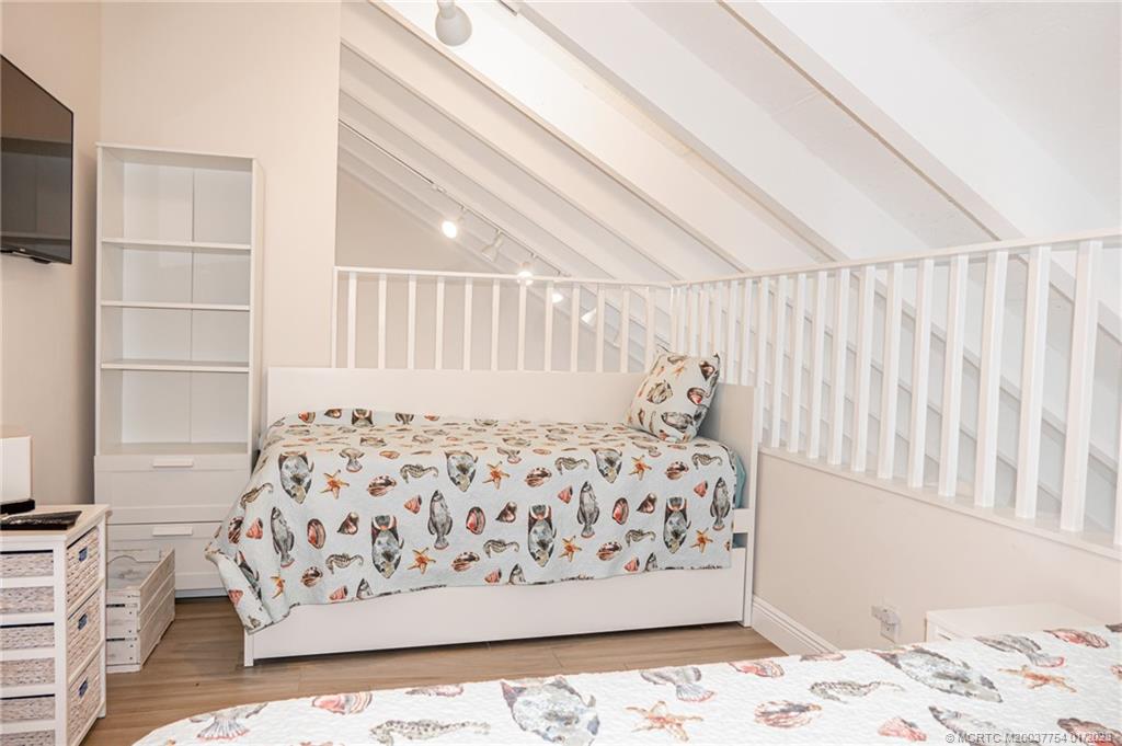 245 Northeast MacArthur Boulevard, Unit 5 Stuart, FL 34996 - Photo 34 of 38 a bed sitting in a bedroom next to a window