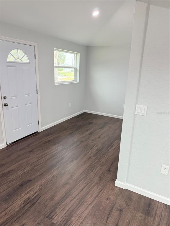 103 South Roger Avenue Arcadia, FL 34266 - Photo 11 of 22 an empty room with wooden floor and windows
